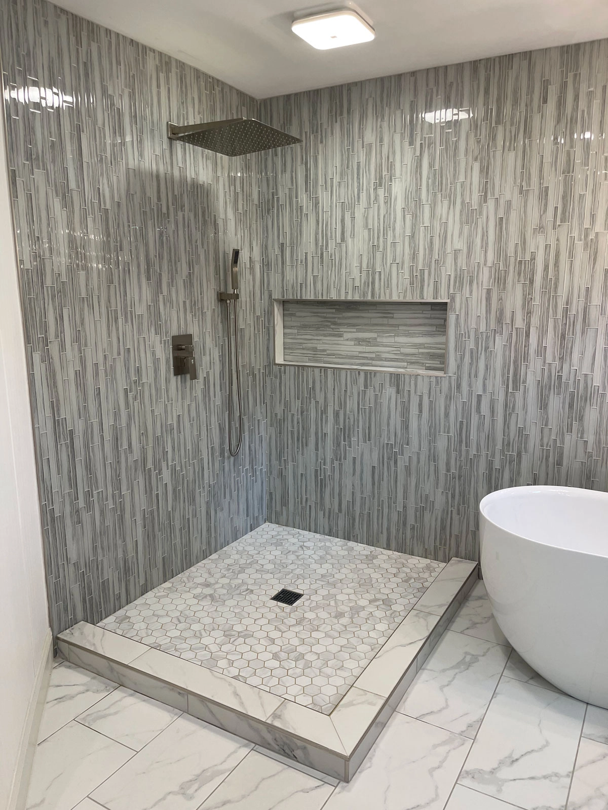 Modern bathroom with tiled walls and freestanding tub